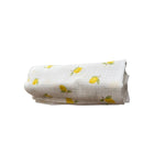 Baby NaturHere maxi muslin swaddle blanket with a white background and a yellow lemon print. Made of 100% cotton.