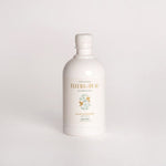 A white bottle of Fleur de Peau body wash with gold and green text and illustration, set against a seamless light gray background.