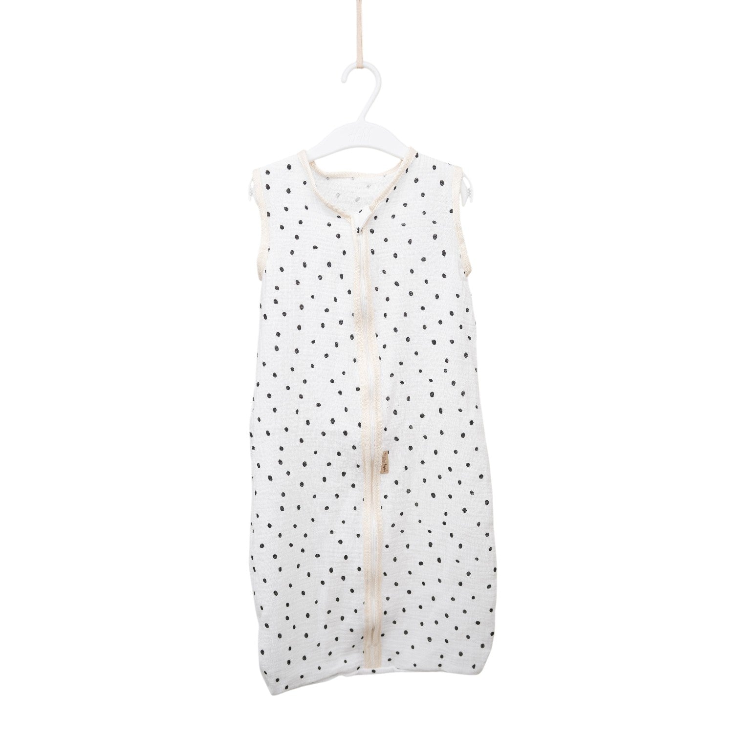 Baby Natur white sleeveless sleeping bag with black polka dots, made of soft, breathable cotton. Features a front zipper.