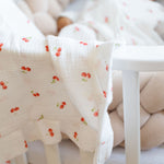 Baby NaturMuslin blanket with a cherry print, soft and breathable, perfect for cribs and strollers.