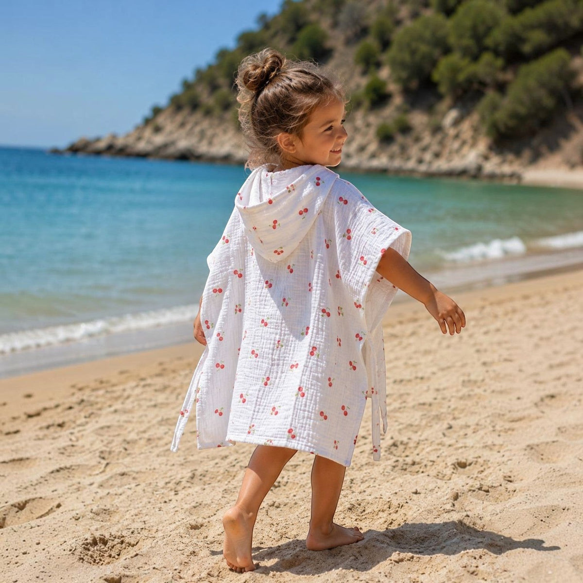 Baby Natur white muslin poncho for kids with cherry print, hooded, perfect for beach or pool.