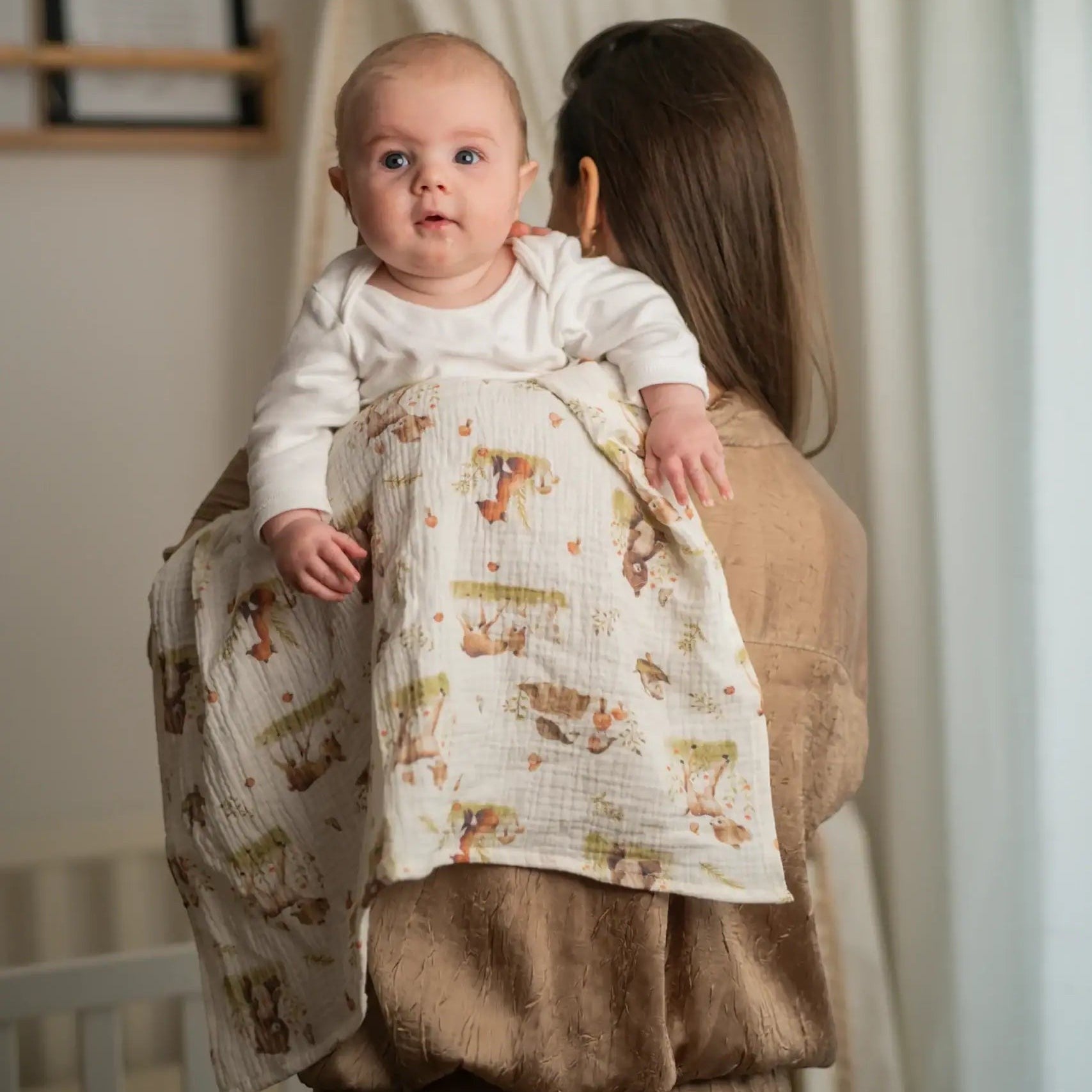 Baby NaturHere 100% cotton muslin swaddle blanket with woodland animal print, perfect for swaddling or as a burp cloth.