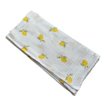 Baby NaturStandard tetra diaper with a white background and a pattern of yellow lemons and green leaves. 100% cotton.